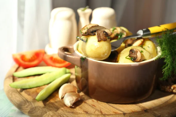 Jonge gekookte aardappelen in de pan met de groenten op tafel in de keuken — Stockfoto