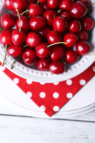 Sweet cherries on plate on wooden background — Stock Photo, Image