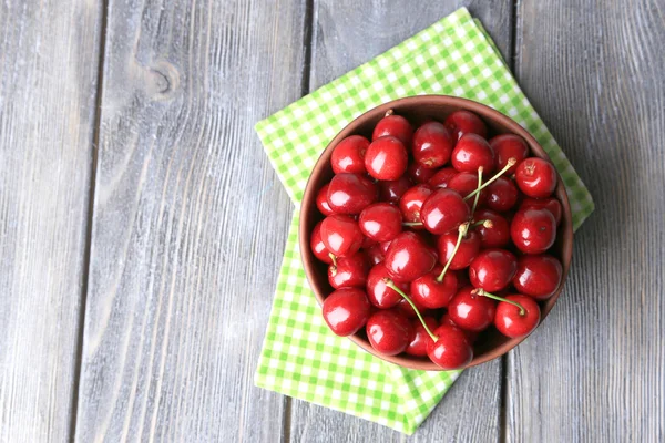 Dolci ciliegie in ciotola di colore su sfondo di legno — Foto Stock