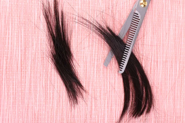 Cut hair and scissors on tile background — Stock Photo, Image