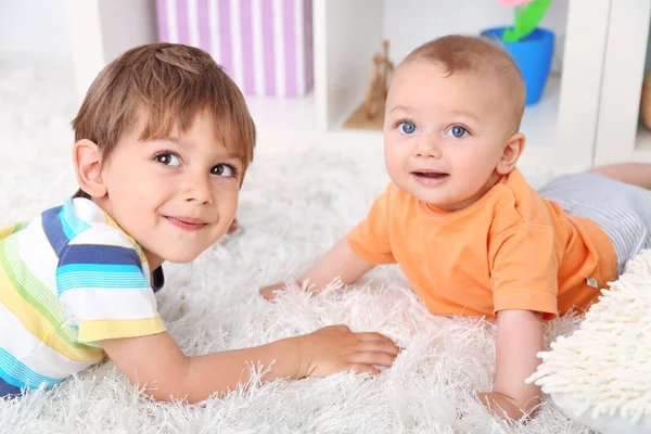 Schattige kleine jongens liggen op tapijt — Stockfoto