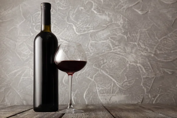 Бутылка красного вина с бокалом — стоковое фото