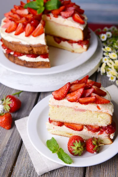 Delicious biscuit cake with strawberries on table close-up — Stock Photo, Image