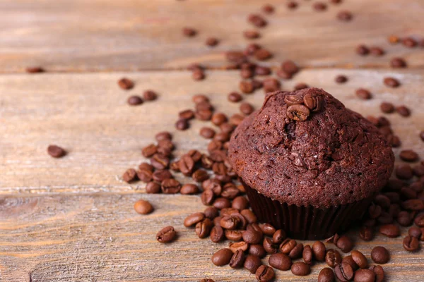 Choklad muffin och kaffe korn på trä bakgrund — Stockfoto