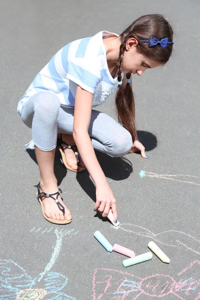 Roztomilá dívka, kreslení křídou na asfalt — Stock fotografie