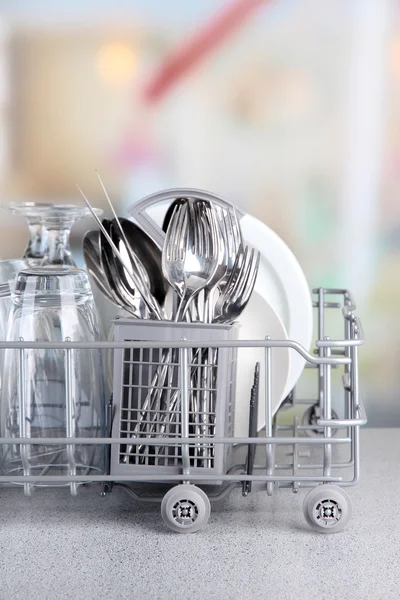 Clean dishes drying on metal dish rack on light background — Stock Photo, Image