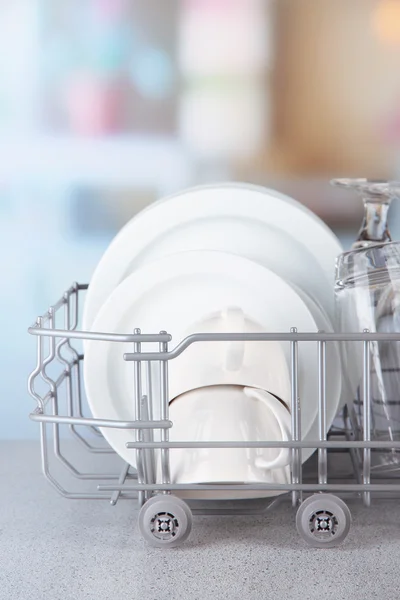 Clean dishes drying on metal dish rack on light background — Stock Photo, Image