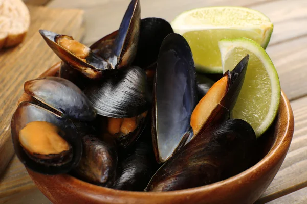 Mussels with lime in bowl on wooden table — Stock Photo, Image