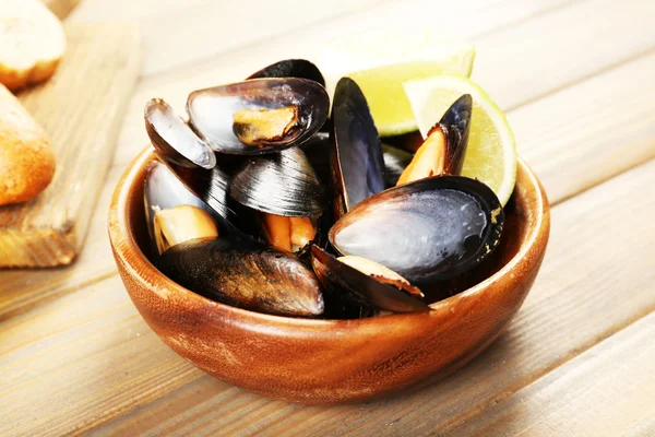 Mussels with lime in bowl on wooden table — Stock Photo, Image