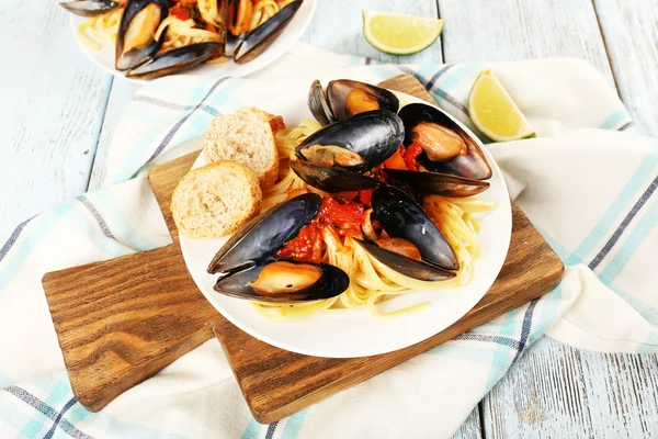 Tasty noodles with mussels on table — Stock Photo, Image
