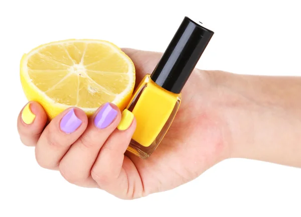 Женская рука со стильными красочными ногтями держа свежий лимон и бутылку с лаком для ногтей — стоковое фото