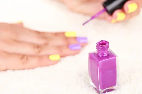Vrouwelijke handen met stijlvolle kleurrijke nagels en nagellak flessen — Stockfoto