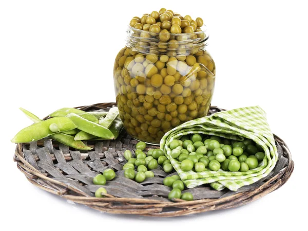 Fresh  and canned peas in glass jar on wicker mat, isolated on white — Stock Photo, Image