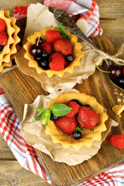 Смачні тарталетки з ягодами на дерев'яному столі — стокове фото
