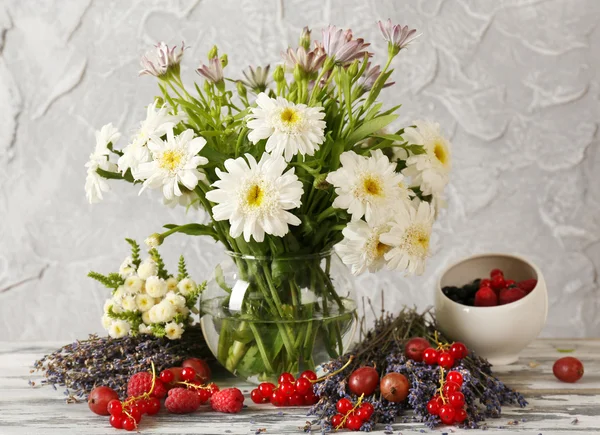 Натюрморт с цветами и фруктами на столе — стоковое фото
