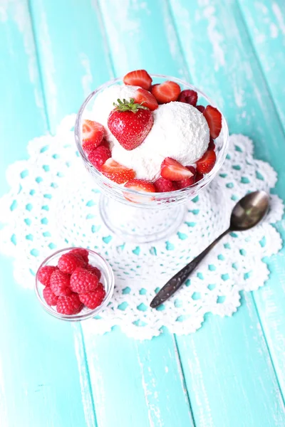 Helado cremoso con frambuesas en plato en cuenco de vidrio, sobre fondo de madera de color —  Fotos de Stock