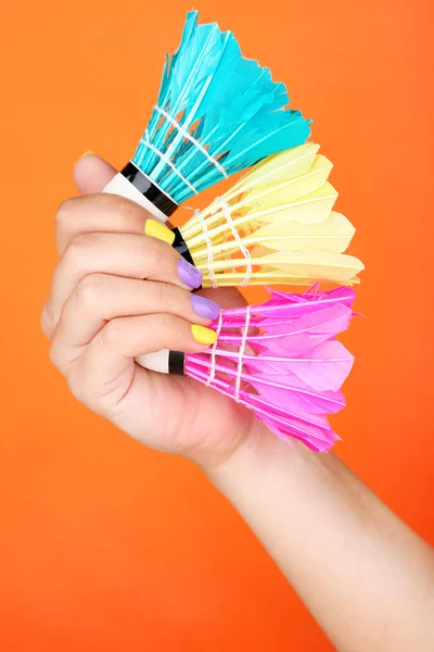 Female hand with stylish colorful nails holding shuttlecocks — Stock Photo, Image