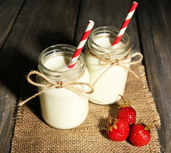 Melk in flessen met papier rietjes — Stockfoto