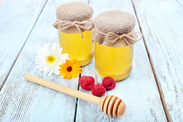 Vaso pieno di delizioso miele fresco e fiori selvatici sul tavolo di legno — Foto Stock