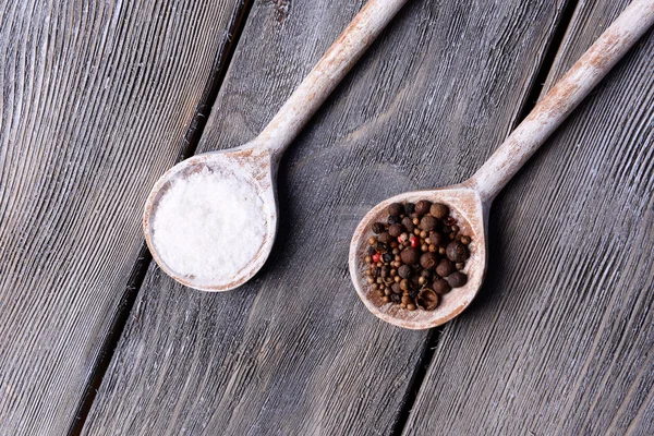 Sal e pimenta em colher em mesa de madeira close-up — Fotografia de Stock