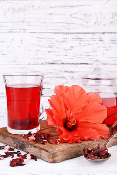Chá e flor de hibisco a bordo, sobre fundo de madeira — Fotografia de Stock