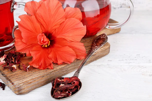 Chá e flor de hibisco a bordo, sobre fundo de madeira — Fotografia de Stock