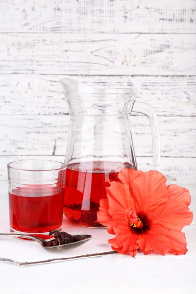 Chá de hibisco frio em jarro de vidro com flor de hibisco em fundo de madeira — Fotografia de Stock