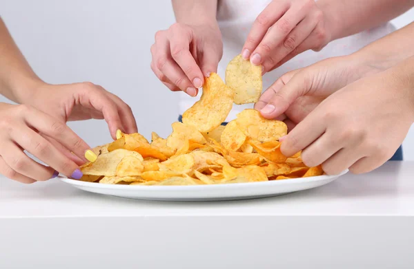 Les mains des gens prennent des chips du bol — Photo