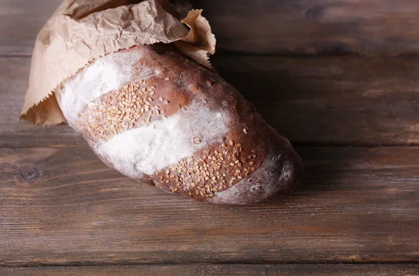 Pane in sacchetto di carta su sfondo di legno — Foto Stock
