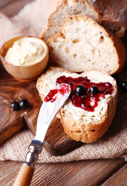 Pain frais au beurre fait maison et confiture de cassis sur fond de bois — Photo