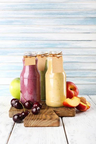 Bottles of delicious smoothie on table, close-up — Stock Photo, Image