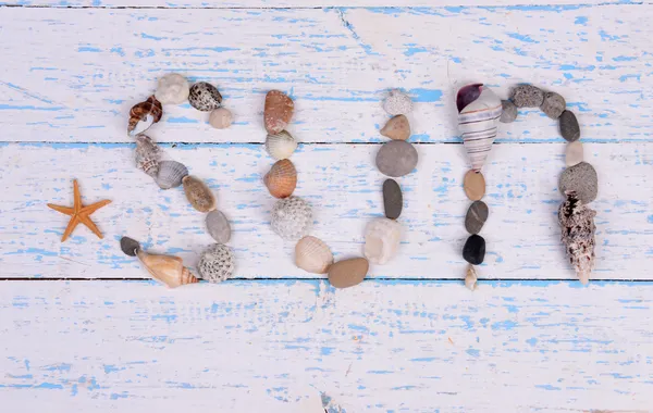 Word sun made from sea shells and stones on wooden background — Stock Photo, Image