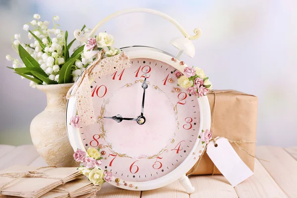 Relógio de alarme vintage bonito com flores no fundo de luz — Fotografia de Stock