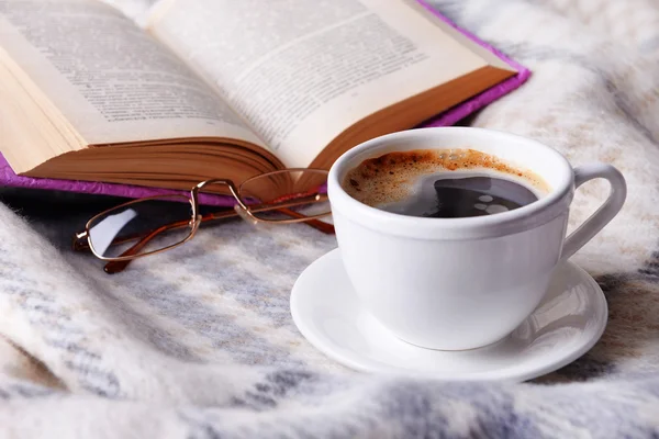 Kopje koffie op plaid met boek — Stockfoto