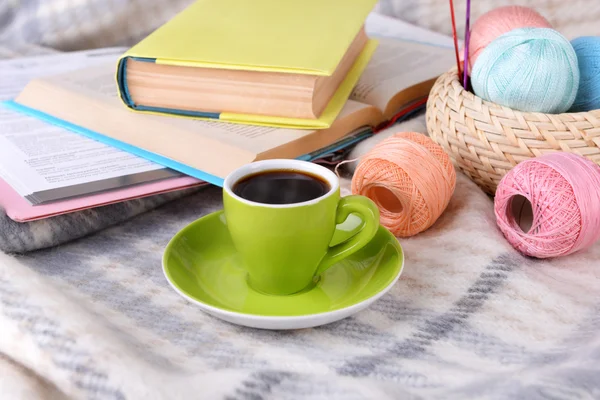 Coupe de café et de fil pour tricoter sur carreaux avec livres close-up — Photo