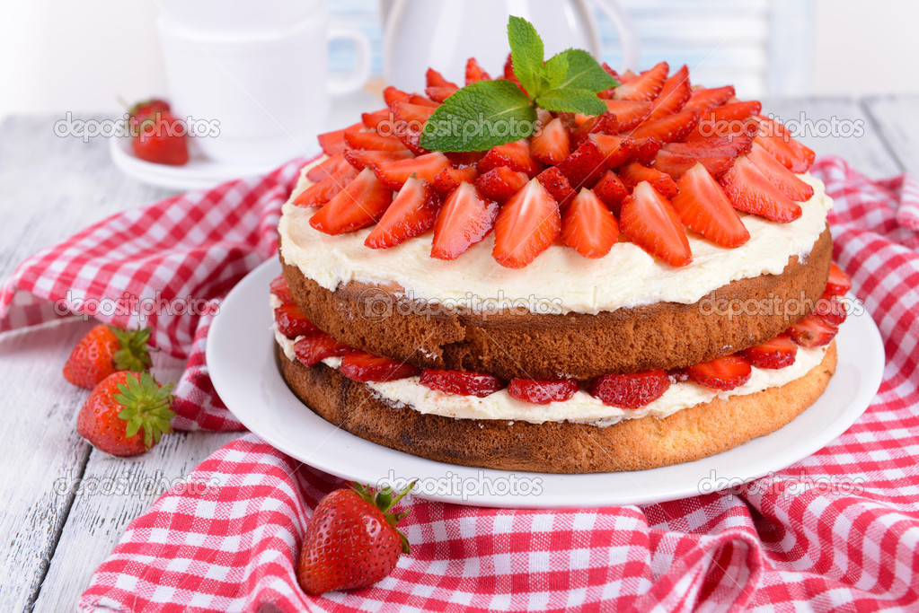 Delicious biscuit cake with strawberries on table close-up
