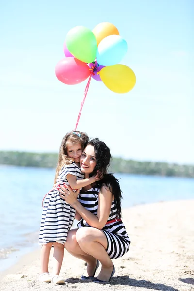 Gelukkig moeder en dochter op het strand — Stockfoto