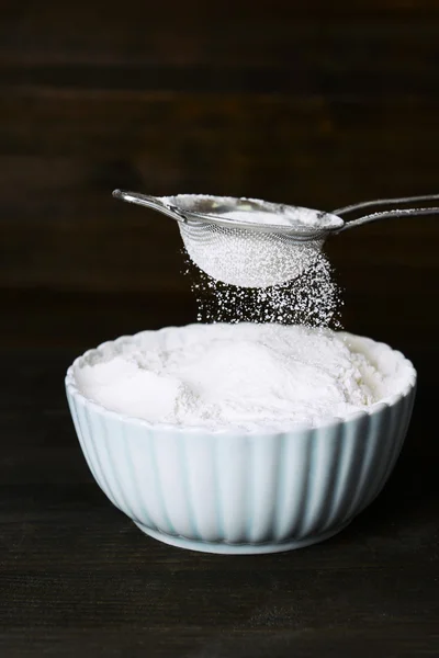 Sålla mjöl i skål på bordet — Stockfoto