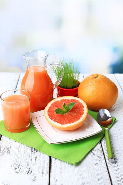 Half of grapefruit, glass jug with fresh juice — Stock Photo, Image