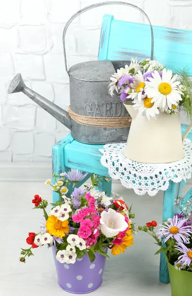 Květiny v dekorativní kbelíky — Stock fotografie