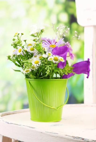 Flowers in decorative bucket — Stock Photo, Image