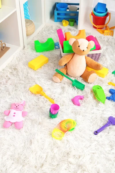 Juguetes coloridos en alfombra esponjosa en la habitación de los niños —  Fotos de Stock