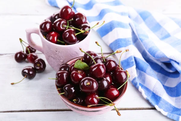 Sweet cherries in color bowl and mug — Stock Photo, Image