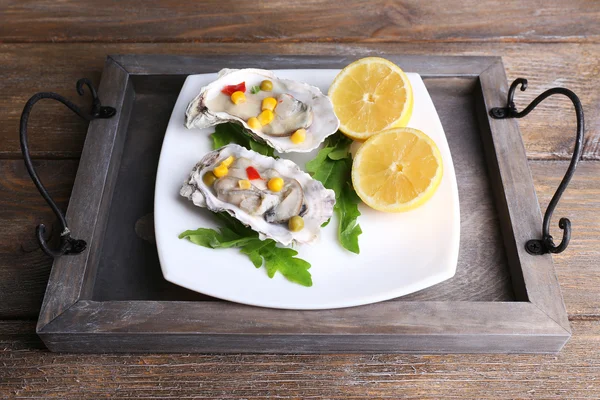 Lekkere gekookte oesters in de schaal op houten tafel — Stockfoto