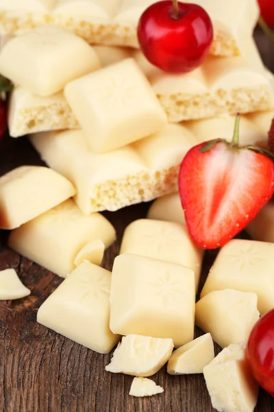 Broken white chocolate bar with fresh strawberries