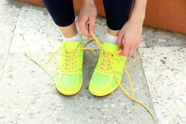 Женщина завязывающая шнурки — стоковое фото
