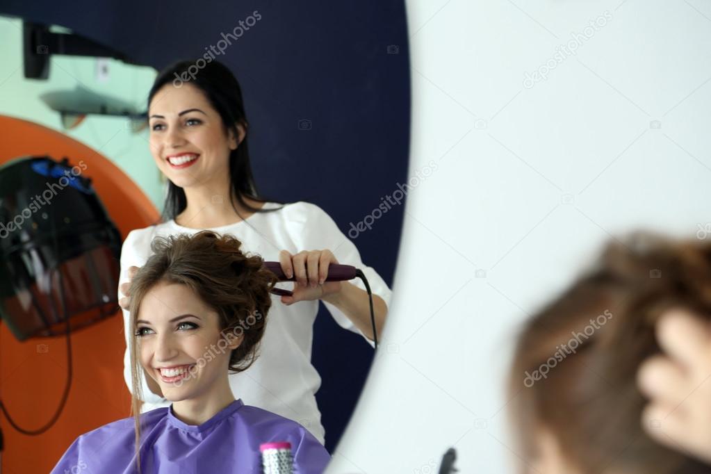 Woman hairdresser do hairstyle girl