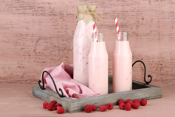 Flessen van smakelijke raspberry smoothie dranken — Stockfoto