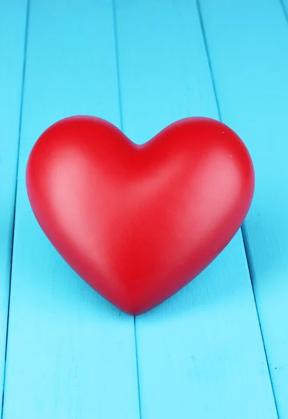 Dekoracyjne czerwone serce z bliska na niebieskim drewnianym stołem — Zdjęcie stockowe