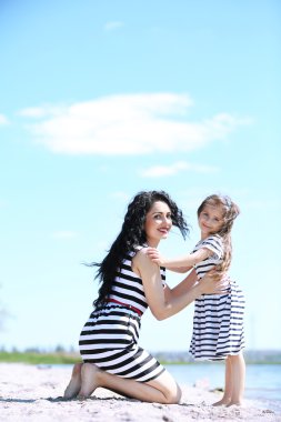 mutlu anne ve kızı. Sahilde yürüyüş